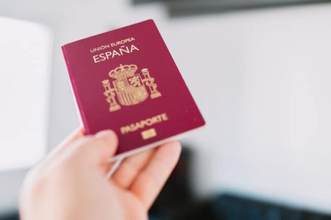 Hand holding a Spanish passport.