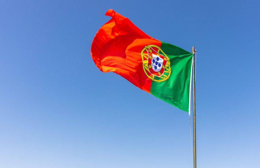 A beautiful shot of the Portuguese flag waving in the calm bright sky