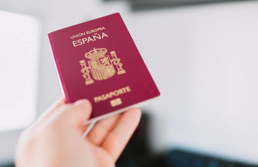 Hand holding a Spanish passport.